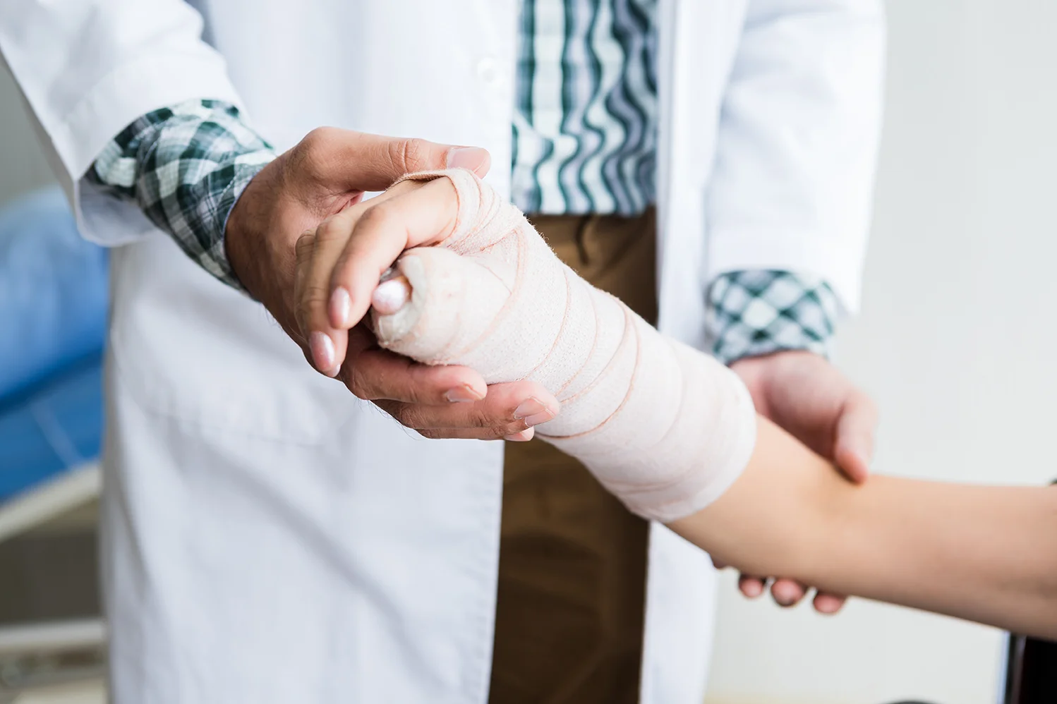 Close-up of man doctor of checking splint the arm of female patient