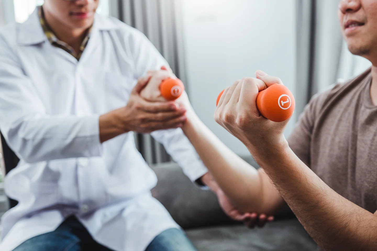 Physiotherapist man giving exercise with dumbbell treatment